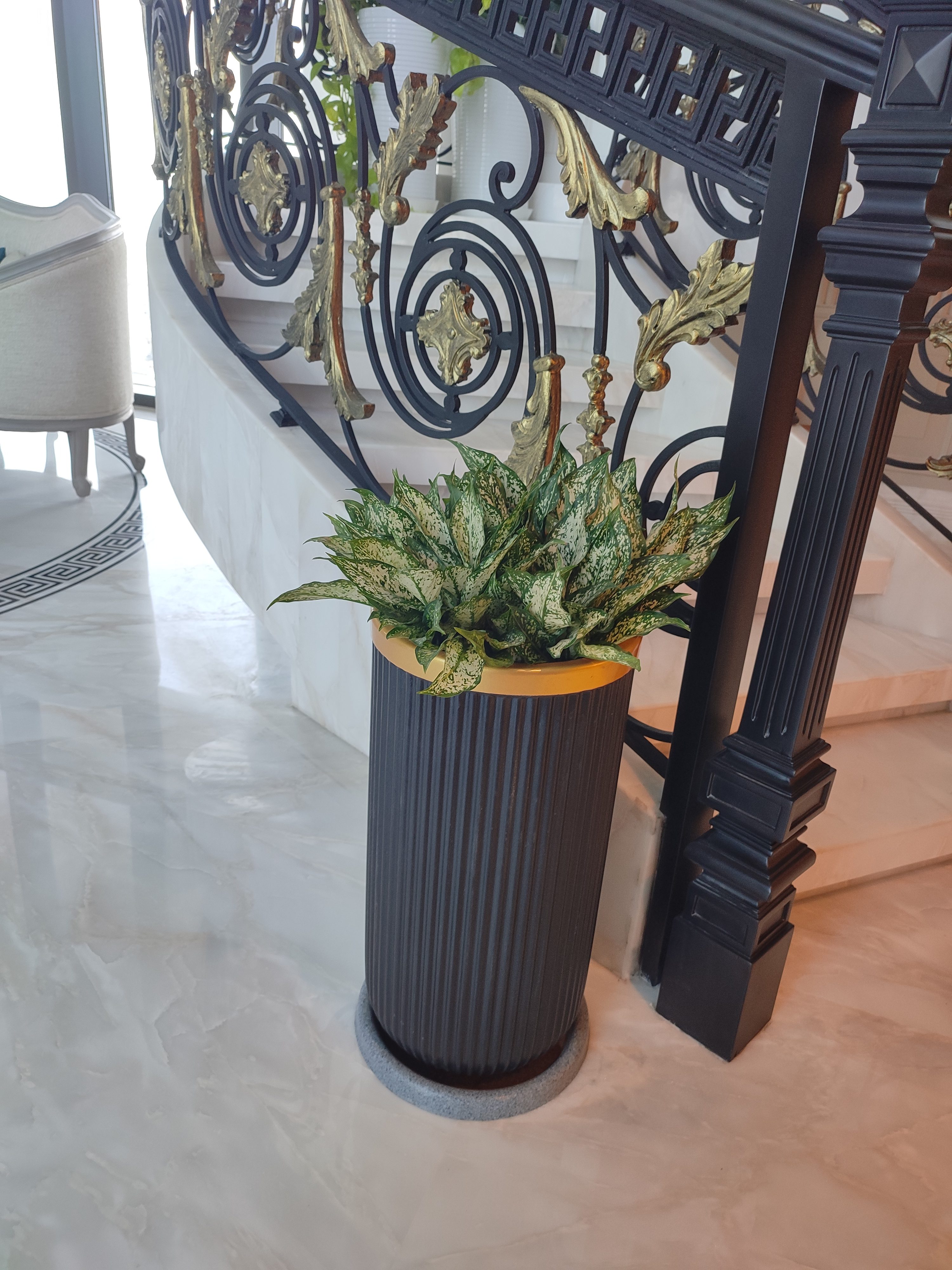 Staircase base — Aglaonema in brass bowl on fluted pedestal